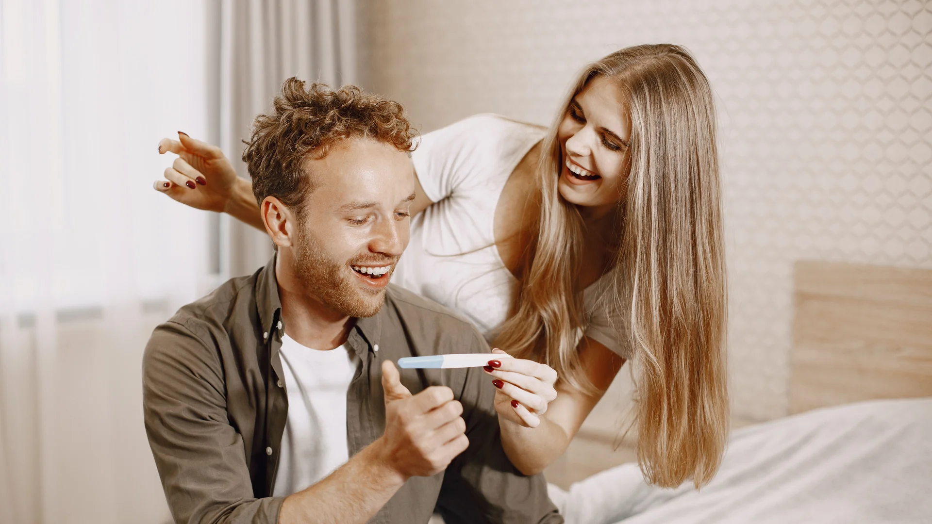 Couple celebrating positive pregnancy test after successful fertility treatment